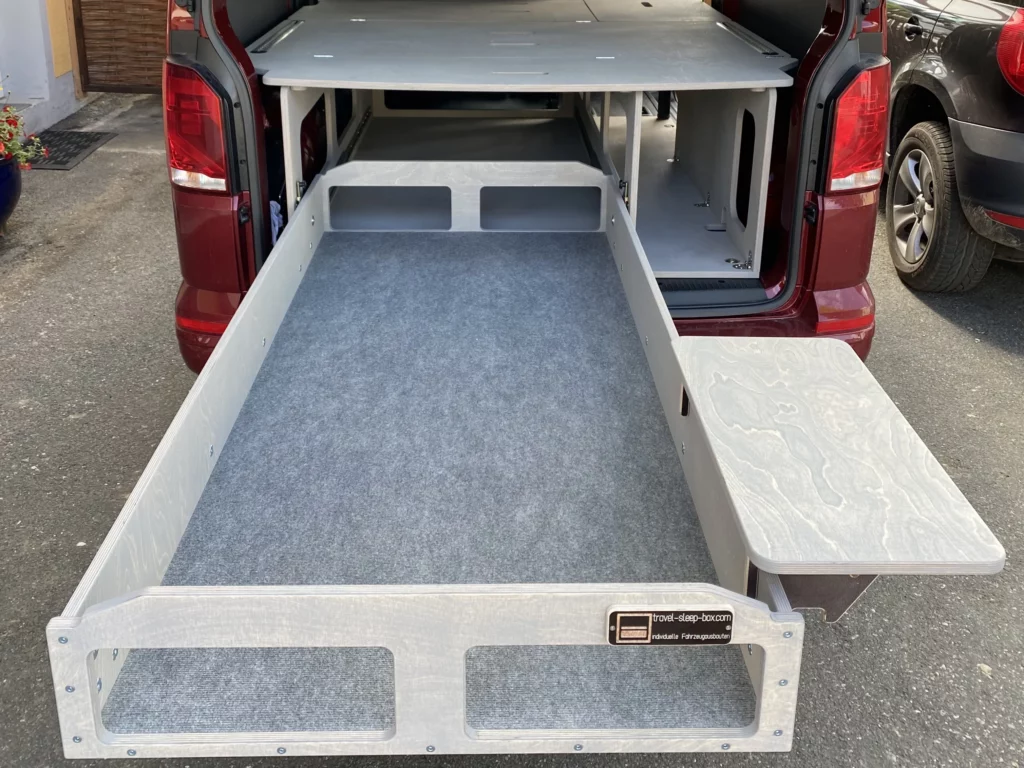 Transporter langer Radstand mit ausgezogener TRAVEL-SLEEP-BOX Heavy Duty, zeigt langlebige Konstruktion und großzügigen Stauraum.
