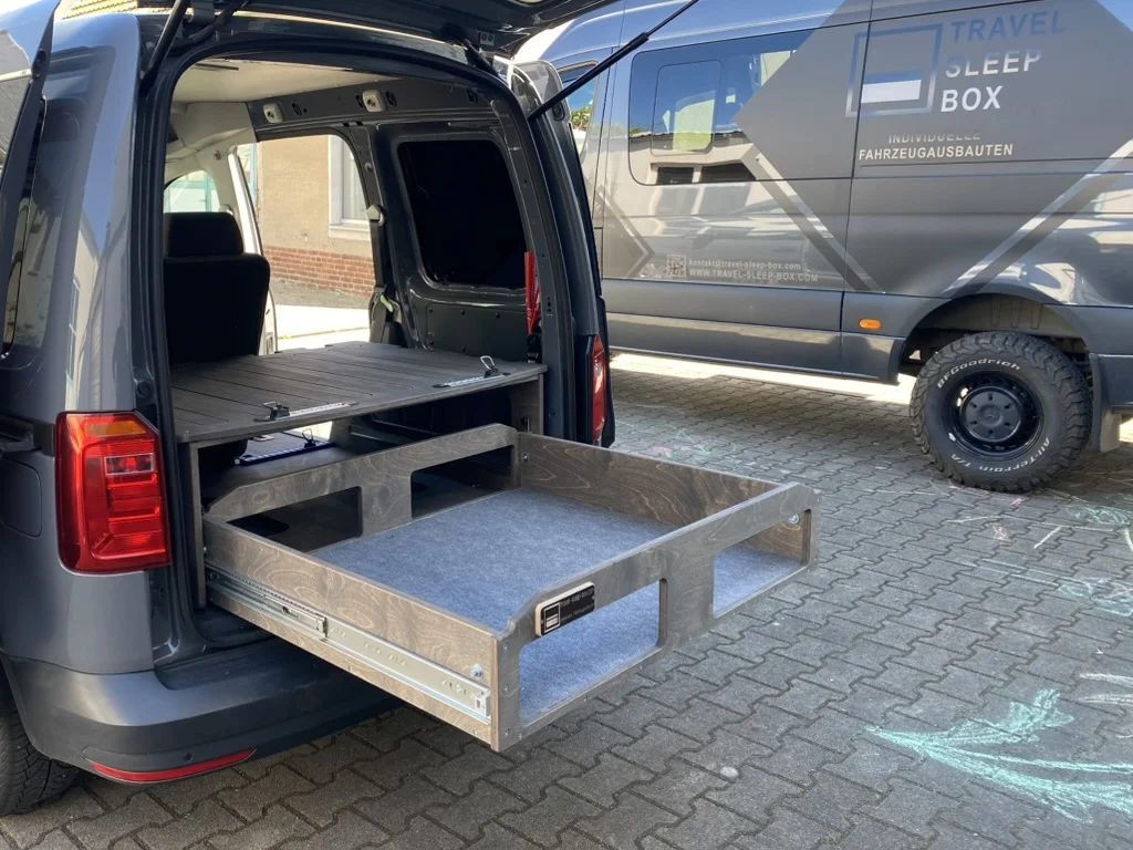 VW Caddy mit TRAVEL-SLEEP-BOX, zeigt funktionale Schlaf- und Stauraumlösung für Camping und Alltag