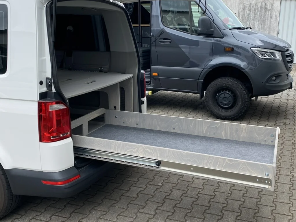 TRAVEL-SLEEP-BOX Heavy Duty im VW Caravelle langer Radstand, ausgezogen, zeigt robusten Schlaf- und Stauraum für Reisen.