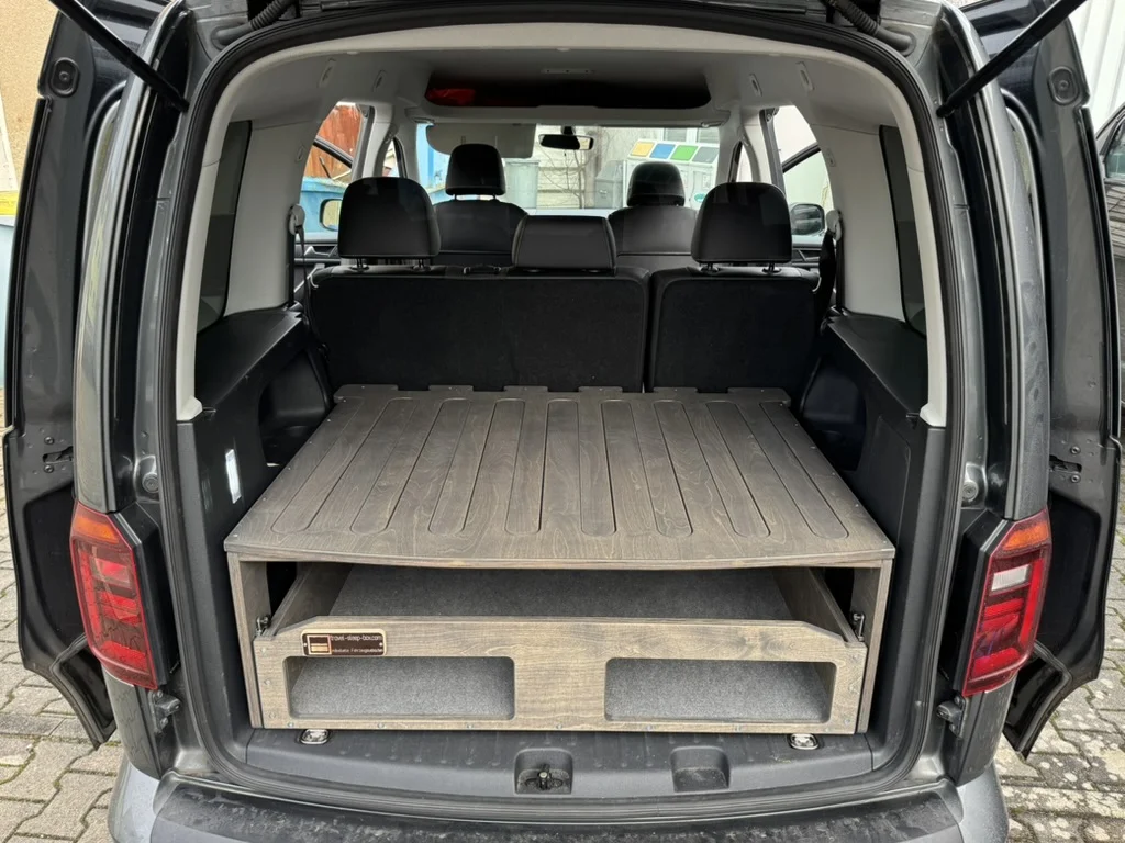 TRAVEL-SLEEP-BOX im VW Caddy, zeigt kombinierte Schlaf- und Stauraumlösung mit großer Schublade